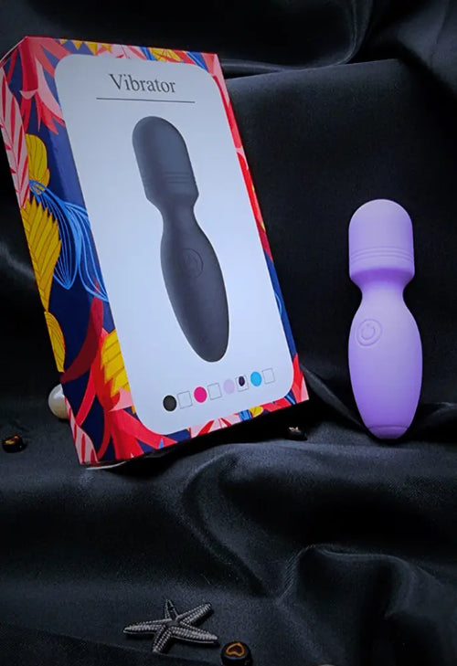 Close-up of the purple mini wand on satin highlighting smooth medical-grade silicone finish.