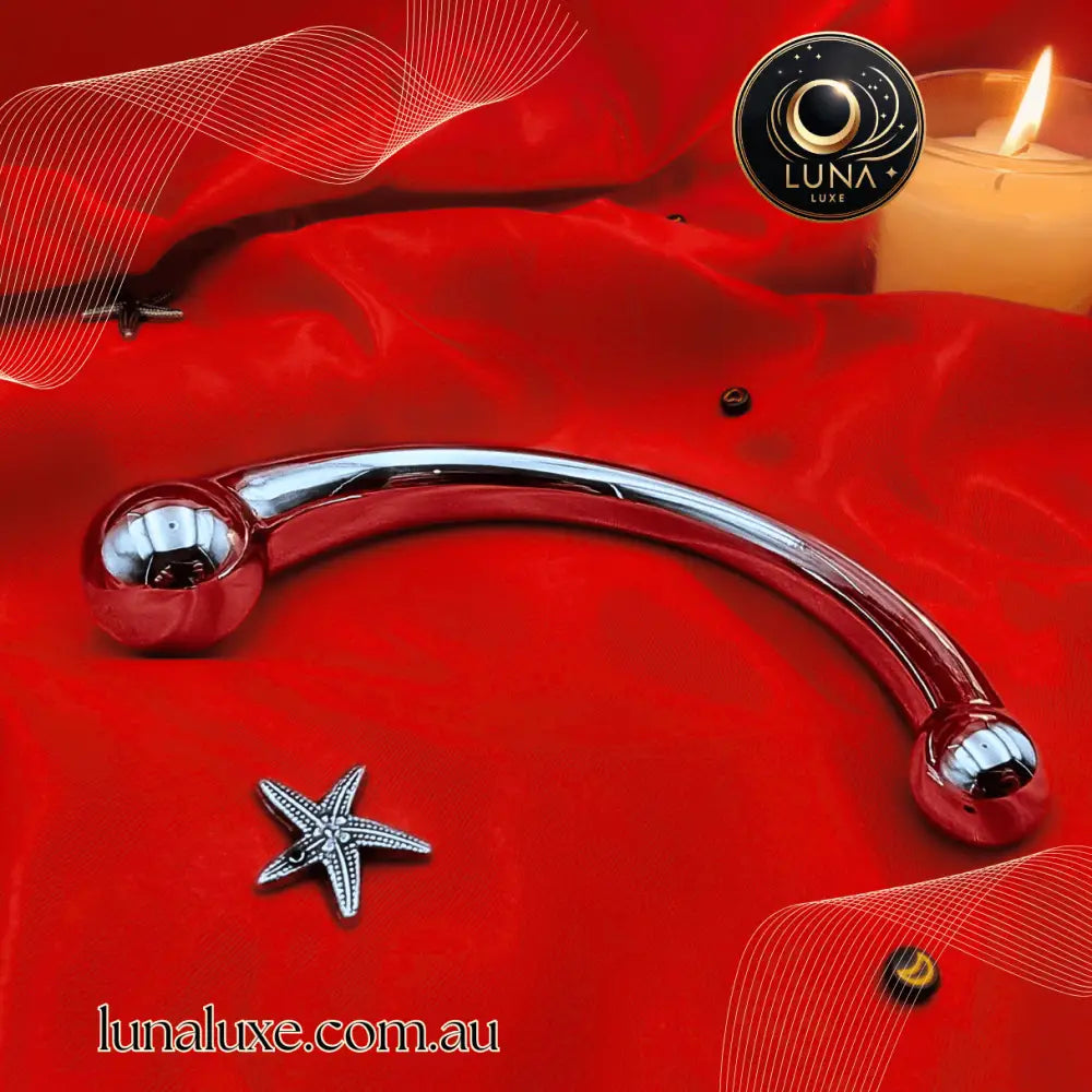 Polished stainless-steel curved wand on red satin, dual rounded bulbs for G-spot or prostate stimulation.