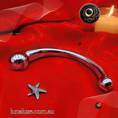 Polished stainless-steel curved wand on red satin, dual rounded bulbs for G-spot or prostate stimulation.