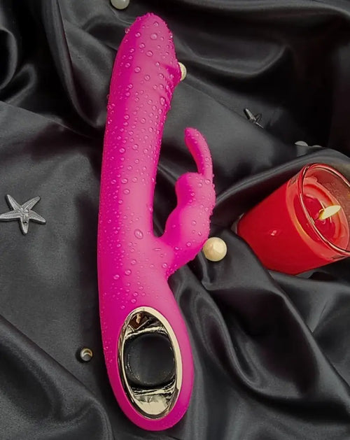 Three-quarter view on fabric—velvety silicone body with an angled external ear set.