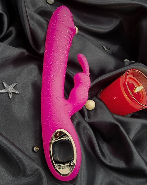 Three-quarter view on fabric—velvety silicone body with an angled external ear set.