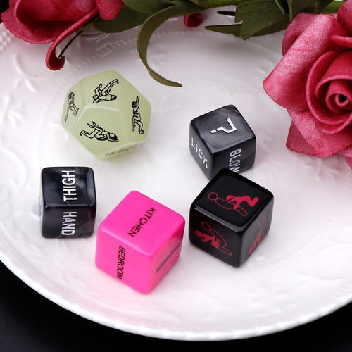 Close-up of pink, black, and green dice showing commands like kiss, bite, and spank.