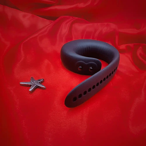 Side angle of the vibrating ring on fabric, highlighting curved inner channel and flexible body.