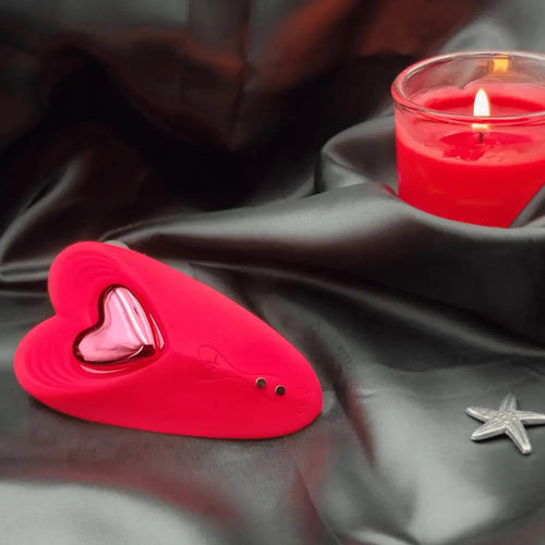 Discreet red wearable next to a wine glass—quiet public play with Bluetooth or long-distance control.