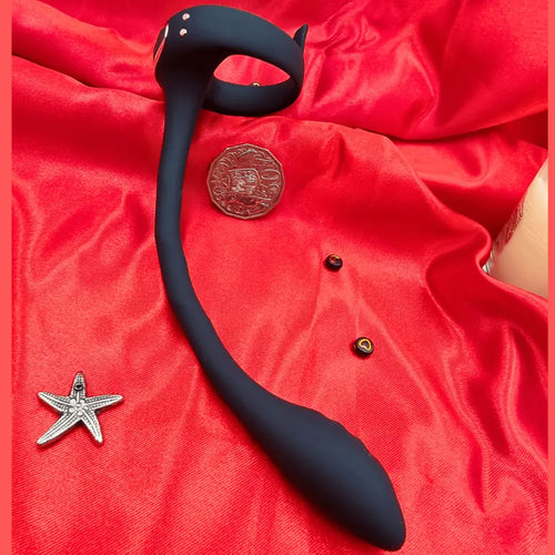 Close view of the prostate toy’s control module on fabric, emphasizing power button and soft silicone.