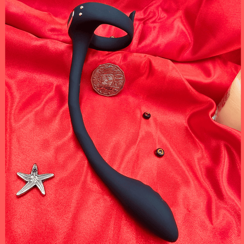 Close view of the prostate toy’s control module on fabric, emphasizing power button and soft silicone.
