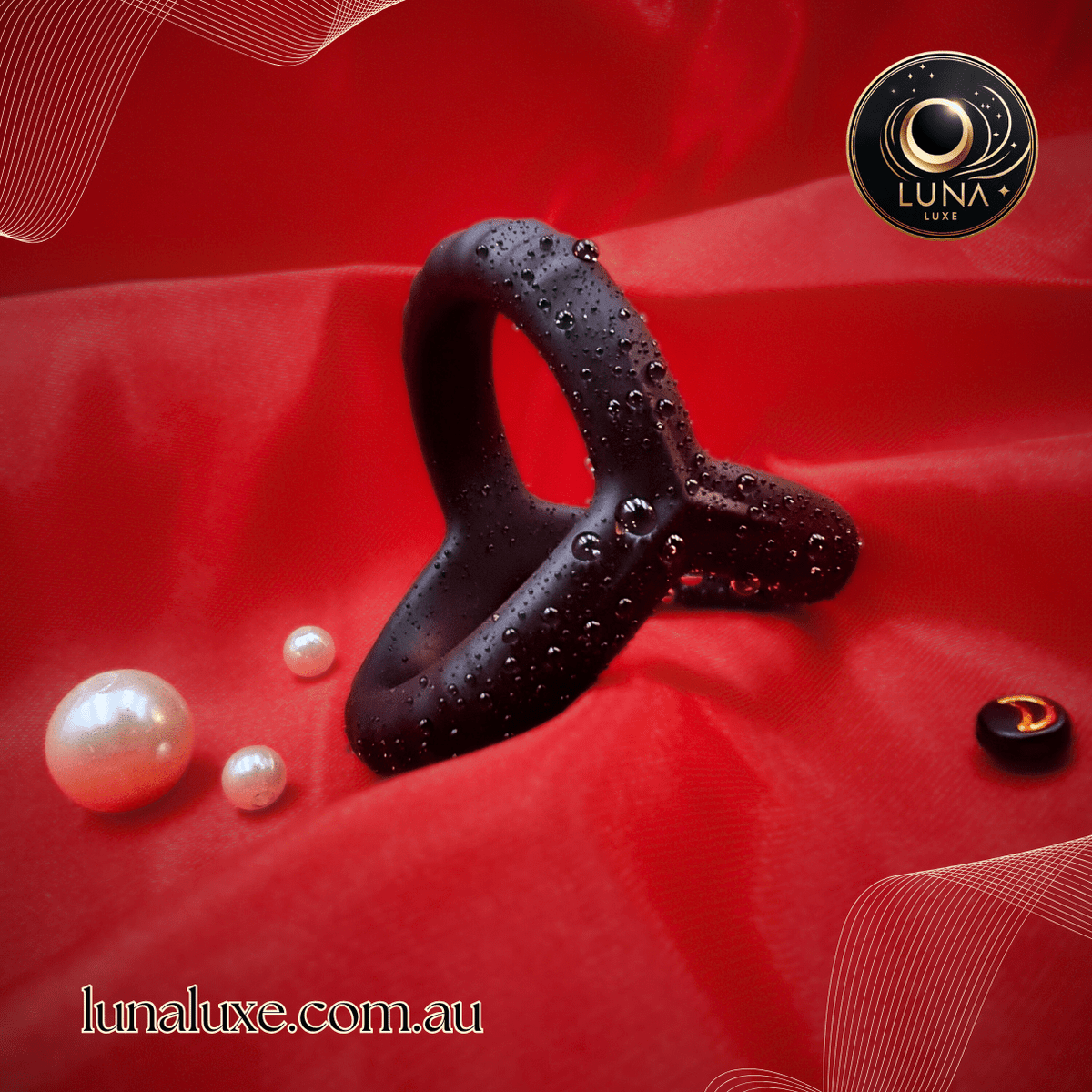 Black triple silicone cock ring on red fabric with water droplets, linked triangular design for shaft and balls.