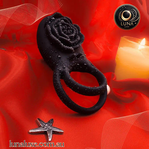 Black vibrating cock ring with rose clitoral stimulator on red satin, soft silicone body.