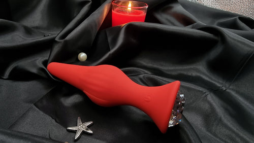 Side profile of the red silicone butt plug, displaying ergonomic shape for comfortable insertion.