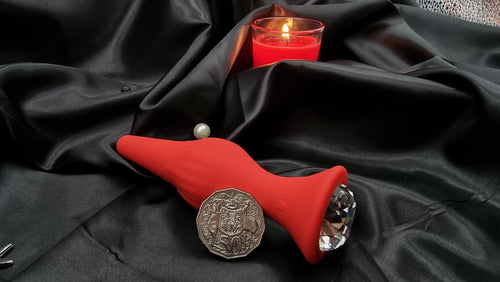 Close-up of the faceted crystal base on the red anal plug, flared stopper for safe wear.